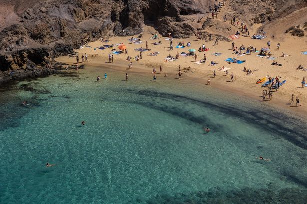   شعب شمس حمام الشمس ويسبحون في بلايا دي باباجايو ، وهو جزء من شاطئ لوس Ajaches Natural Park 