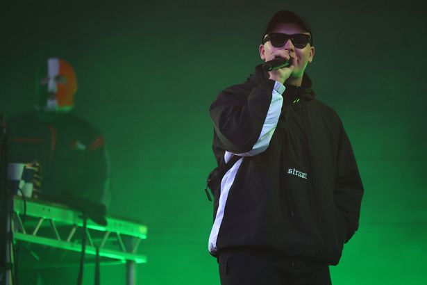 Liam O'Hanna من Northern Irish Hip Hop Trio Kneecap يؤدي على خشبة المسرح خلال مهرجان مستيقظ واسع 2025