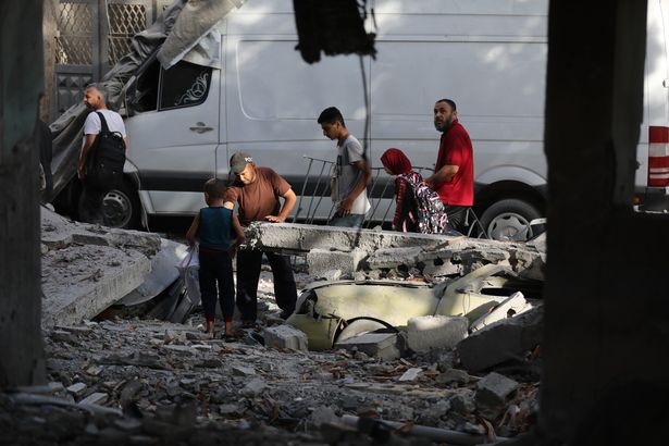   يبحث الفلسطينيون في المنطقة التي تلت غارة جوية إسرائيلية عند الفجر في المدرسة