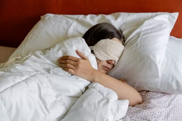 امرأة تنام مع قناع نائم على رأسها
