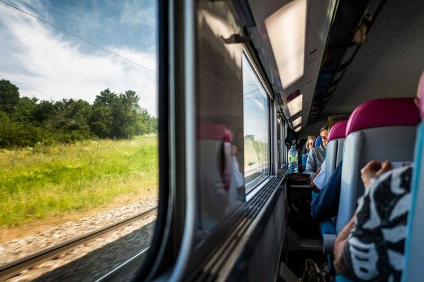 ركاب في قطار Ouigo TGV ويشاهدون من نافذة القطار إلى المسار