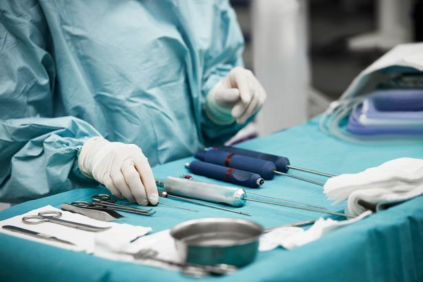 القسم الوسط من جراح التجميل الإناث ترتيب المعدات الجراحية على الطاولة. الطبيب الشاب يستعد للتشغيل. هي في غرفة الطوارئ في المستشفى.