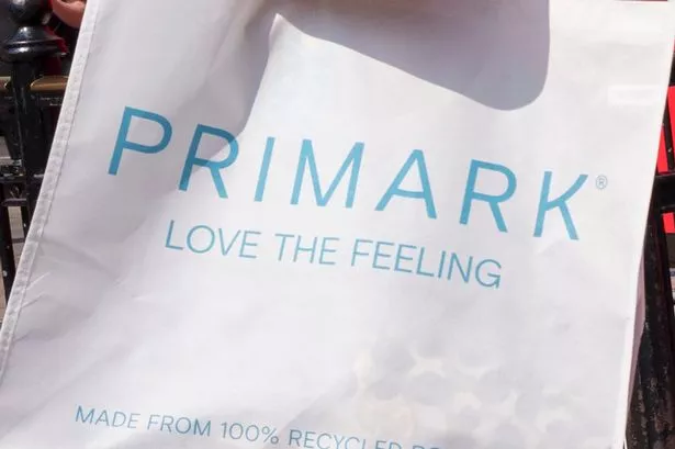 يمشي متسوقي Primark عبر لوحة إعلانية ذات طابع خارج نايك تاون ، ويحتفلون بالجري وألعاب القوى