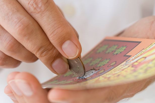 شخص يخدش بطاقة خدش