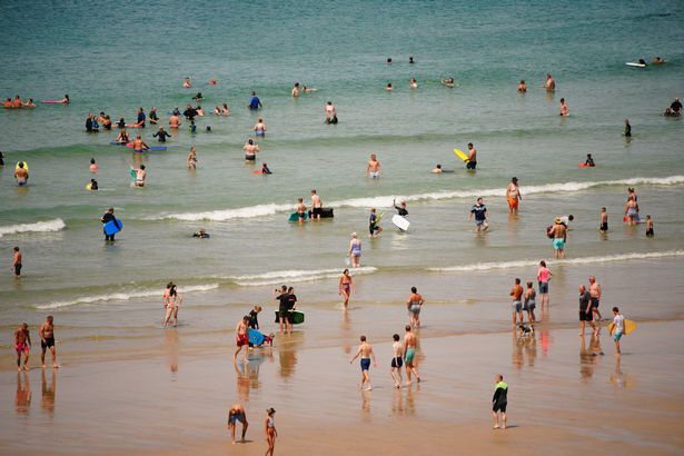 الناس في البحر على شاطئ Perranporth. من المتوقع أن تصل درجات الحرارة إلى 31C في جميع أنحاء وسط إنجلترا يوم الأحد قبل مستويات قياسية في الأسبوع المقبل. تاريخ الصورة: الأحد 17 يوليو 2022. انظر PA Story Weather Weawewave. يجب أن تقرأ الائتمان الصورة: بن بيرشال/سلك