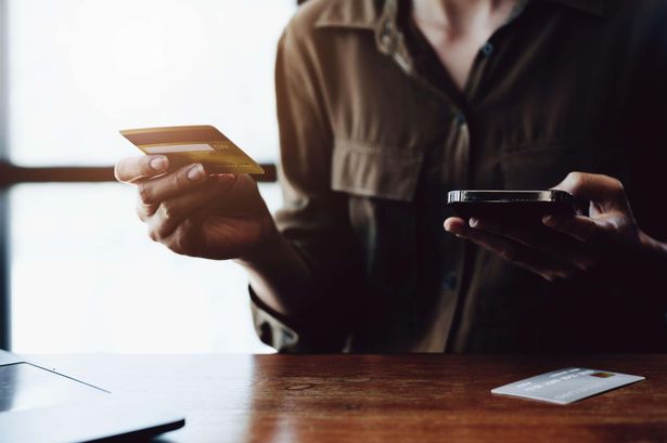 صورة امرأة تحمل بطاقة الائتمان في متناول اليد