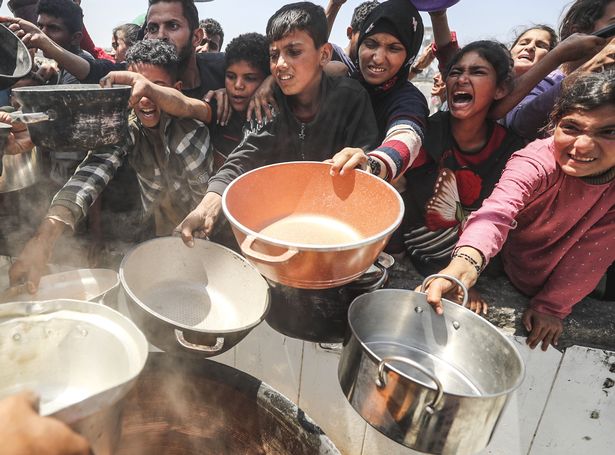 ينتظر الفلسطينيون النازحون ، بمن فيهم الأطفال ، مع الأواني الفارغة لتلقي الطعام الموزعة من قبل المنظمات الإنسانية في معسكر جاباليا للاجئين في قطاع غزة الشمالي في 7 مايو 2025. 
