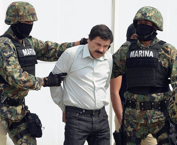 يرافق المارينز أن تجار المخدرات المكسيكي جواكين غوزمان لويرا المعروف أيضًا باسم "El Chapo Guzman" (C) ، حيث يتم تقديمه إلى الصحافة في 22 فبراير 2014