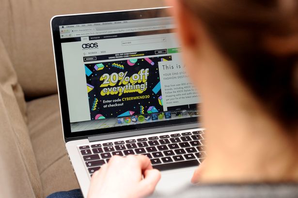 ينظر شخص إلى موقع ASOS على جهاز كمبيوتر محمول
