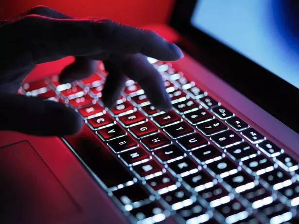 تكتب اليد الغامضة المظلمة على جهاز كمبيوتر محمول في الليل