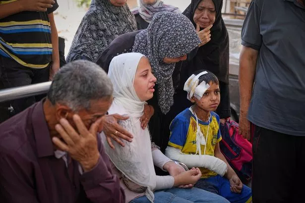 يجلس حمام الفاراني بجوار أخته ، باللون الأبيض ، إلى جانب أفراد الأسرة الآخرين مثل جثة والدهم علاء ، قتل في ضربة جيش إسرائيلية أصيب أيضًا بجروح الصبي ، للدفن في مستشفى شيفا في مدينة غزة ، يوم الثلاثاء ، 24 يونيو ، 2025. (AP Photo Alshrafi)