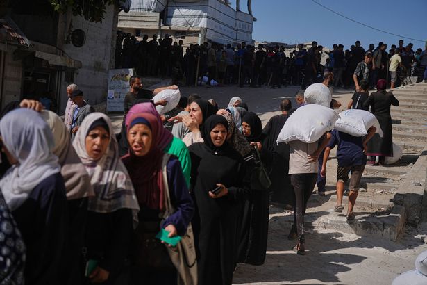 يصطف الفلسطينيون لتلقي أكياس من الدقيق التي وزعها برنامج الأغذية العالمي (WFP) في مدينة غزة ، شمال غزة ، يوم الخميس ، 26 يونيو 2025 (AP Photo/Jehad Alshrafi)
