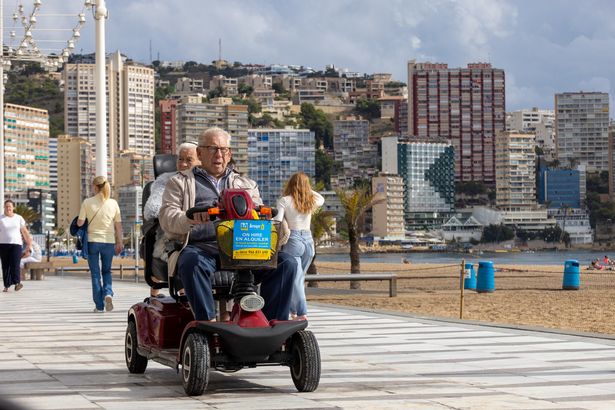 في الصورة زوجين أكبر سنا على سكوتر التنقل المستأجر ، لا يزال يحظى بشعبية كبيرة في بينيدرورم.
