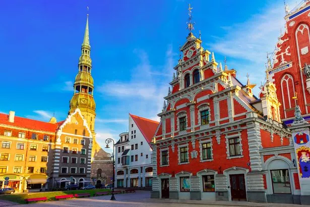 ساحة قاعة المدينة مع House of the Blackheads و Saint Peter Church في بلدة Riga القديمة في المساء ، لاتفيا
