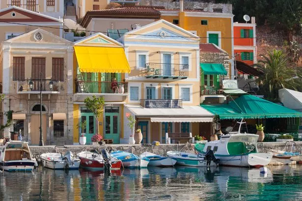 المنازل الكلاسيكية الملونة التي تصطف على الواجهة البحرية ، Gialos (AKA Yialos) ، Symi (AKA Simi) ، Rhodes ، Dodecanese Islands ، South Aegean ، اليونان ، أوروبا.