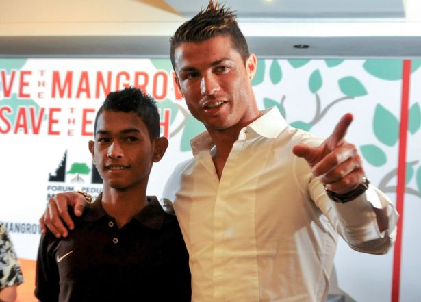 تُظهر هذه الصورة التي التقطت في بالي في 26 يونيو 2013 لاعب كرة القدم كريستيانو رونالدو (ص) لم شملها مع مارتونيس البالغ من العمر 16 عامًا ، وهو أحد الناجين الإندونيسيين في عام 2004 المميت آيت تسونامي الذي التقى به نجم ريال مدريد في عام 2005 خلال مهمة لمساعدة ضحايا تسونامي وقدم مساعدة عائلية. 