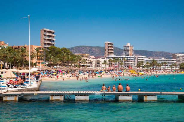 تسترخي العائلة على الرصيف في Playa de Magaluf Beach ، Magaluf ، Mallorca ، Balearic Islands ، Spain
