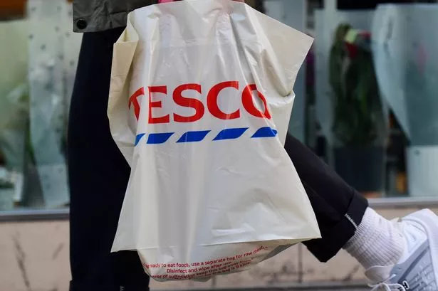 يحمل أحد العملاء حقيبة من التسوق من سوبر ماركت Tesco PLC في لندن