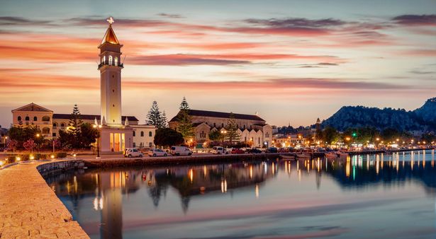 بانوراما من مشهد المدينة ومرفى مدينة Zakynthos خلال الغسق بعد غروب الشمس الصيفي ، البحر الأيوني ، اليونان