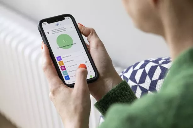 تستخدم امرأة تطبيق National Health Service Covid-19 (NHS) على هاتف ذكي مرتبة بالقرب من Guildford ، المملكة المتحدة ، يوم الاثنين ، 17 مايو 2021