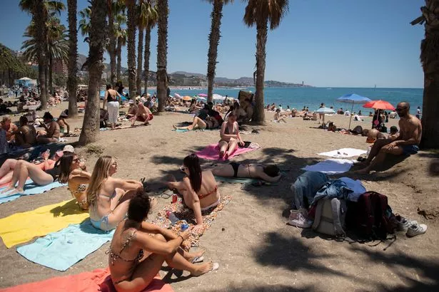 يستمتع رواد الشاطئ بالشمس والبحر في Malagueta Beach في Malaga. تتعامل الشرطة الإسبانية مع سلسلة من الجرائم العنيفة