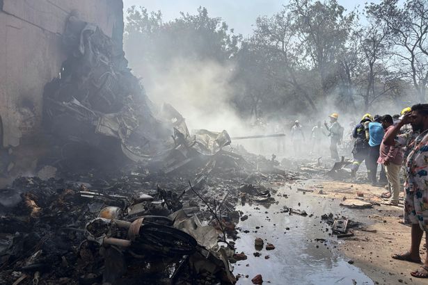يقف الناس حول الحطام في موقع مشهد الحادث.