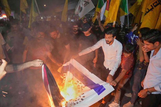 المتظاهرون الذين يحترقون صور الإسرائيلية والأعلام الأمريكية في بغداد ، العراق