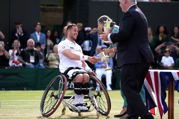 يتلقى Alfie Hewett الكأس بعد فوزه بلقب الكرسي المتحرك للرجال في ويمبلدون