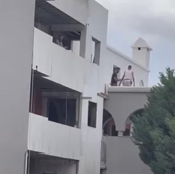 يقوم العمال بتثبيت الألواح الزجاجية على شرفات فوق الزوجين