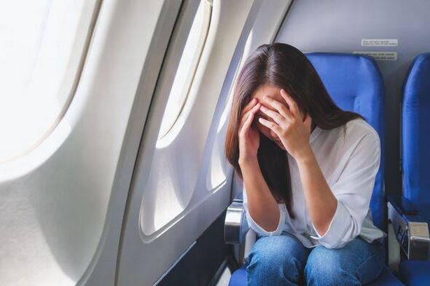 صورة صورة لامرأة تحصل على الهواء والصداع أثناء السفر على متن الطائرة