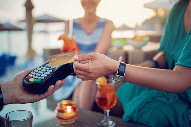 يدفع الصديقات كوكتيلاتهم على شريط الشاطئ باستخدام بطاقة الائتمان بدون اتصال