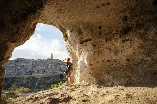 امرأة تنظر إلى الرأي من كهف من Matera ، Basilicata ، إيطاليا
