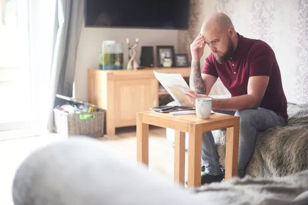 مالك المنزل يقرأ الأوراق على الأريكة في غرفة معيشته