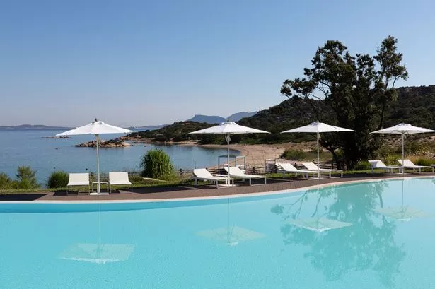 Sunloungers على طول المسبح في Cala Cuncheddi Sardinia