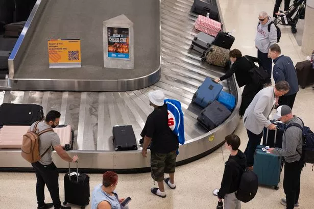 الركاب الذين يجمعون وينتظرون أمتعتهم في حزام النقل 