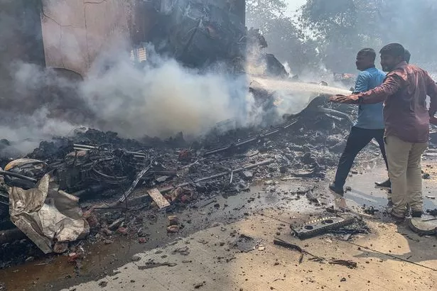يعمل رجال الإطفاء في الموقع الذي تحطمت فيه رحلة طيران الهند 171 في منطقة سكنية بالقرب من المطار في أحمد آباد في 12 يونيو 2025.