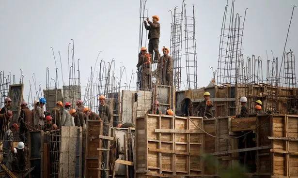 يعيد العمال بناء المنازل في سينويجو ، كوريا الشمالية