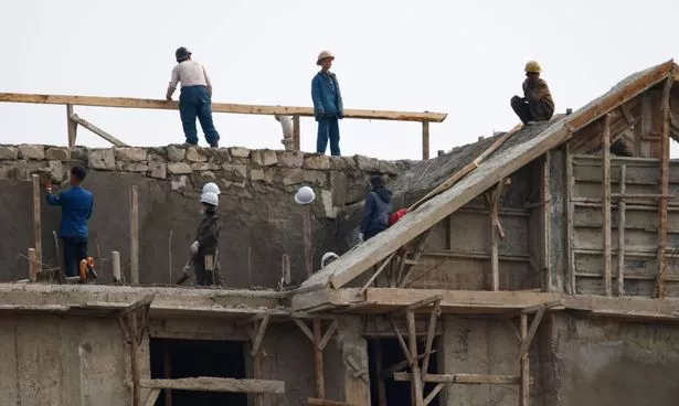 يعيد العمال بناء المنازل في سينويجو ، كوريا الشمالية ، بعد الفيضان