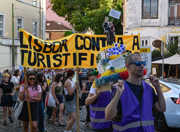 لشبونة ، البرتغال-15 يونيو: متظاهرين من "Assembleia da graã§a â €" Parar O Hotel No Quartel "و" Movimento Polyndo Pela Habitaã§ã £ O "يحملون لافتة مناهضة للسياحة ، وهم يونيون يديرون في يونيو. 2025 في لشبونة ، البرتغال. 
