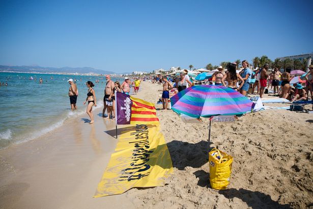 أعضاء في جمعية Mallorca Platja Tour Association يوقع ضد التشبع السياحي على شاطئ Palma de Mallorca في 11 أغسطس 2024 في Mallorca ، إسبانيا