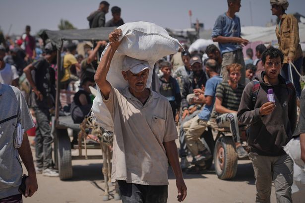 يحمل الفلسطينيون حزم المساعدات الغذائية والإنسانية التي قدمتها مؤسسة غزة الإنسانية ، وهي منظمة مدعومة بالولايات المتحدة ، في رافح ، جنوب غزة ، الخميس ، 26 يونيو 2025 (AP Photo/Abdel Kareem Hana)