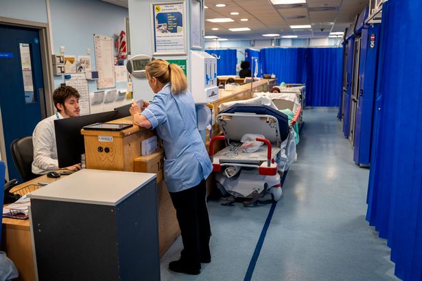 المرضى الذين يعانون من عربات في انتظار ثعبان الأسرة حول جناح الطوارئ في NHS