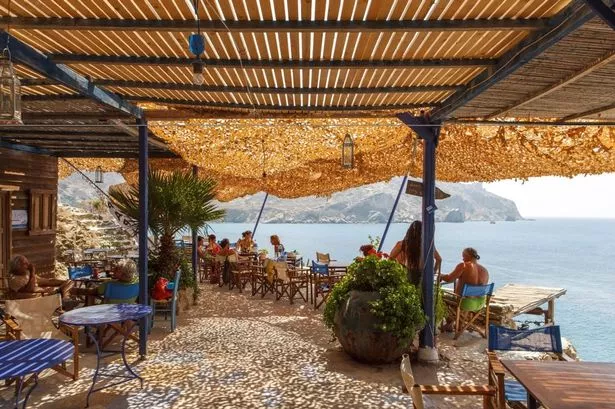 Aghios Nikolaos Beach Tavern في Folegandros يظهر السياح يسترخي