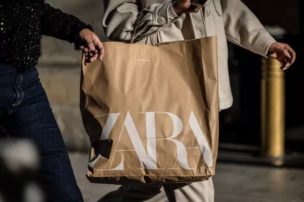 يحمل المتسوق حقيبة من متجر للملابس زارا خلال مبيعات الشتاء