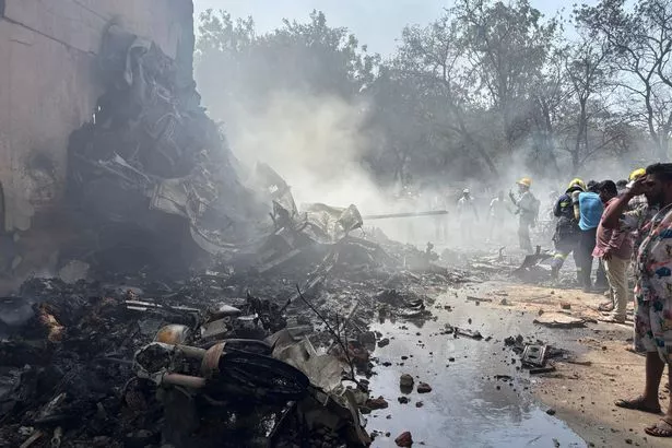 الأشخاص الذين تم تصويرهم يقفون حول حطام الرحلة المحكوم عليهم 171 بعد الحادث