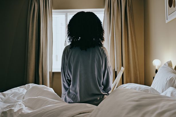 تستيقظ امرأة من الاكتئاب والامرأة تفكر في سريرها في غرفة نومها وهي تنظر من النافذة وتجلس