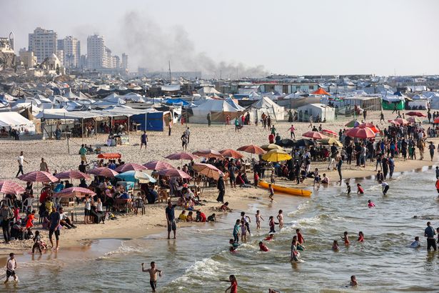 يتجمع الفلسطينيون على الشاطئ بالقرب من معسكر إزاحة مؤقت في مدينة غزة