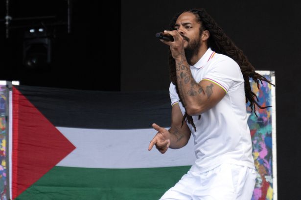 بوبي فيلان يؤدي على خشبة المسرح - إلى خلفية العلم الفلسطيني