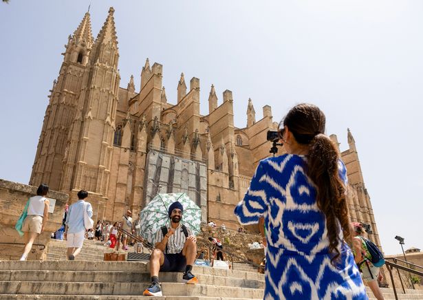 يلتقط السائح صورة أمام كاتدرائية بالما دي مايوركا في 13 يونيو 2025.