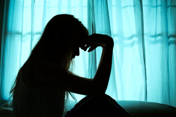 صورة ظلية من امرأة جالسة في السرير على النافذة
